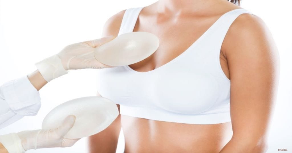 Woman wearing compressing bra after breast augmentation. Holding